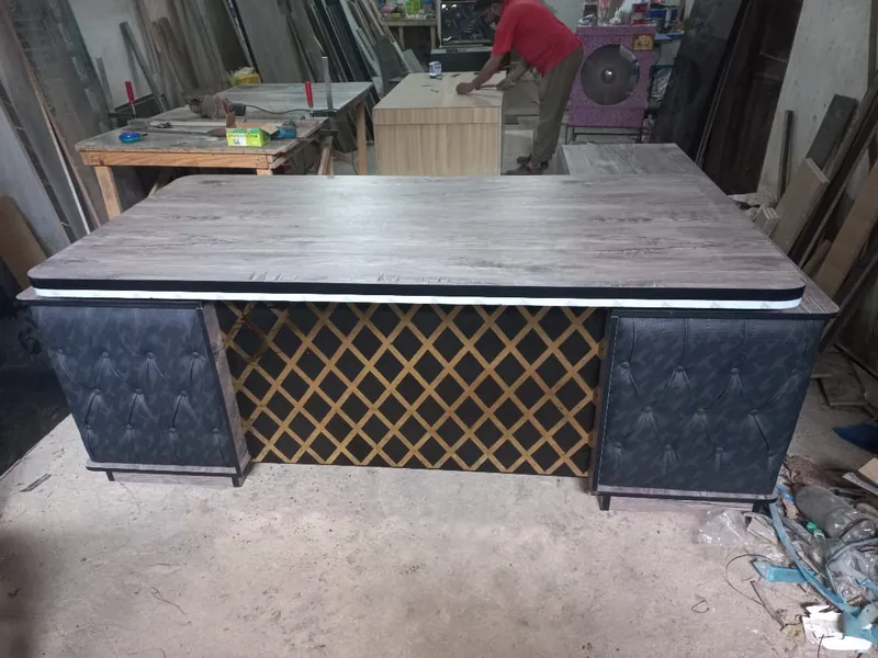 Executive table with tufted side panels and gold lattice front